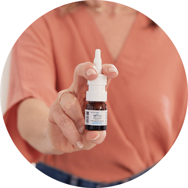 Image of person holding a 4.2 mL bottle of Tyrvaya® (varenicline solution) nasal spray