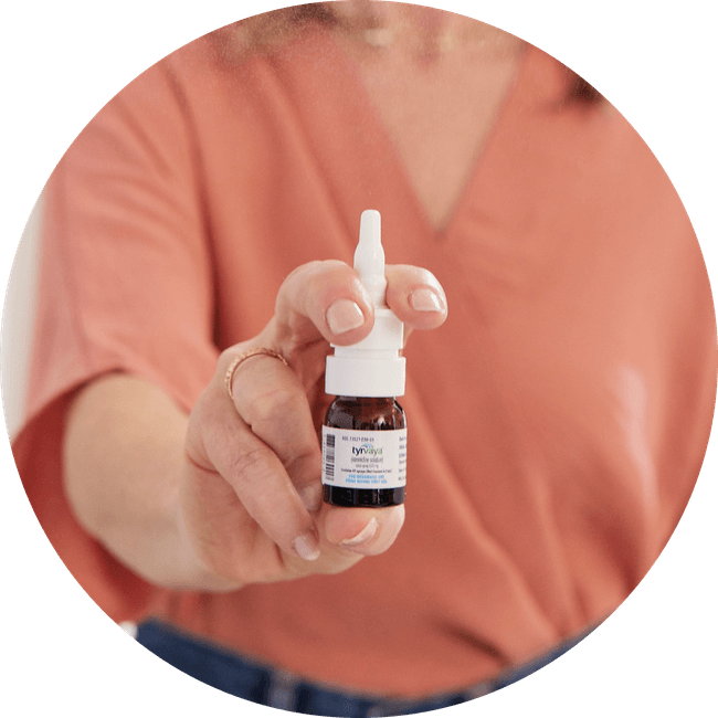 Image of person holding a 4.2 mL bottle of Tyrvaya® (varenicline solution) nasal spray