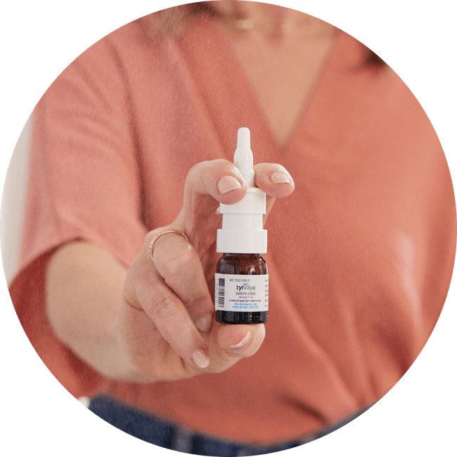 Image of person holding a 4.2 mL bottle of Tyrvaya® (varenicline solution) nasal spray