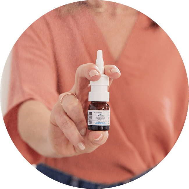 Image of person holding a 4.2 mL bottle of Tyrvaya® (varenicline solution) nasal spray