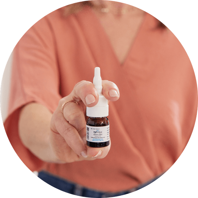 Image of person holding a 4.2 mL bottle of Tyrvaya® (varenicline solution) nasal spray