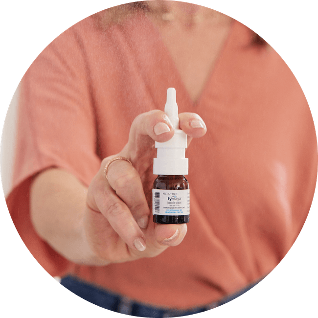 Image of person holding a 4.2 mL bottle of Tyrvaya® (varenicline solution) nasal spray